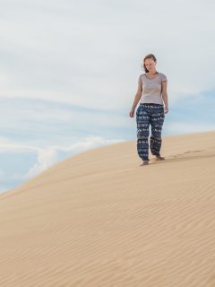 woman on a sand dune - What To Wear on a Desert Safari in Dubai