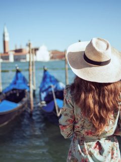 Woman with gondolas - What to wear in Venice in Summer (June, July August)