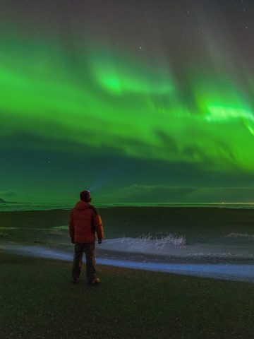 Person and Northern lights in Iceland - what to wear to see the Northern Lights in Iceland