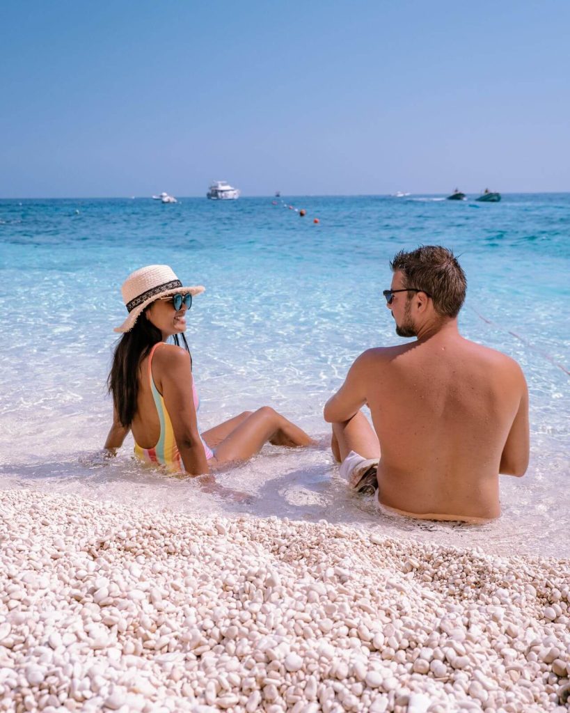 Couple wearing swimwear on beach in Sardinia