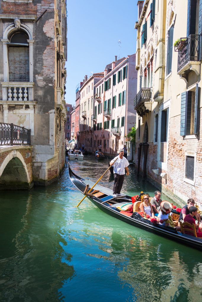 People on gondola on Venice canal in August