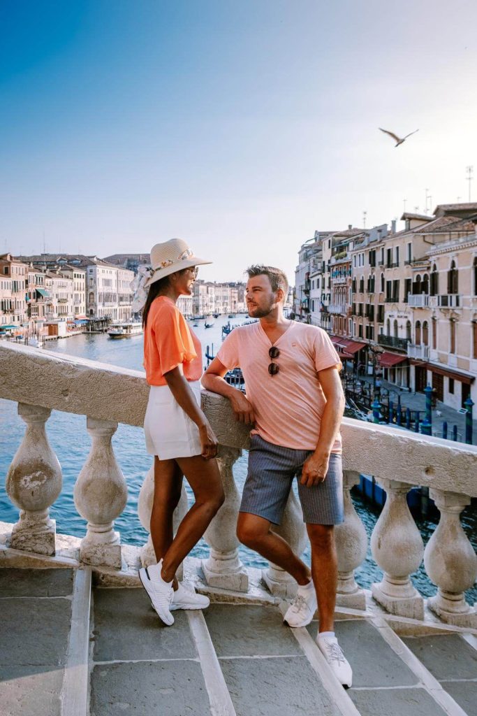 couple on bridge in venice in September with canal in background