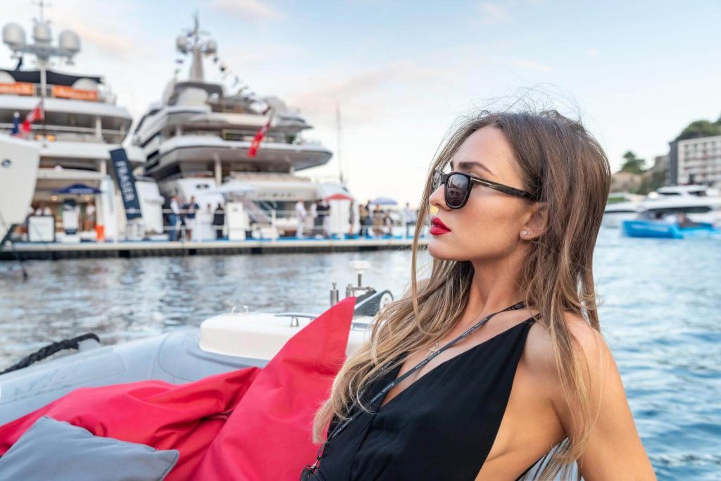 Woman dressed elegantly with yachts in background in Monaco Monte Carlo