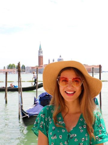 Woman in September in Venice with lagoon and gondolas in background