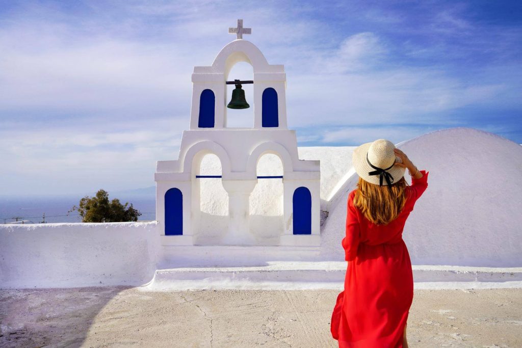 Woman in front of orthodox dress in Greece in summer