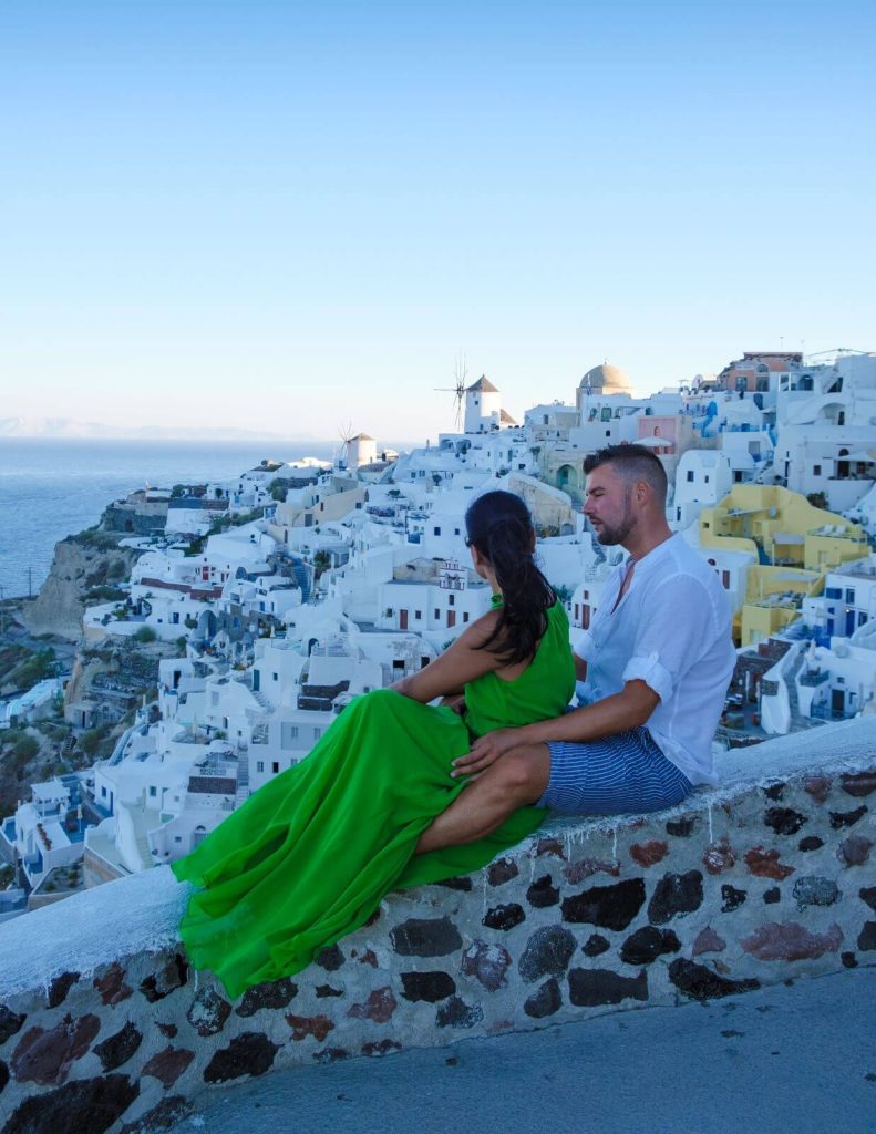 Couple sitting on a wall in Santorini in Greece