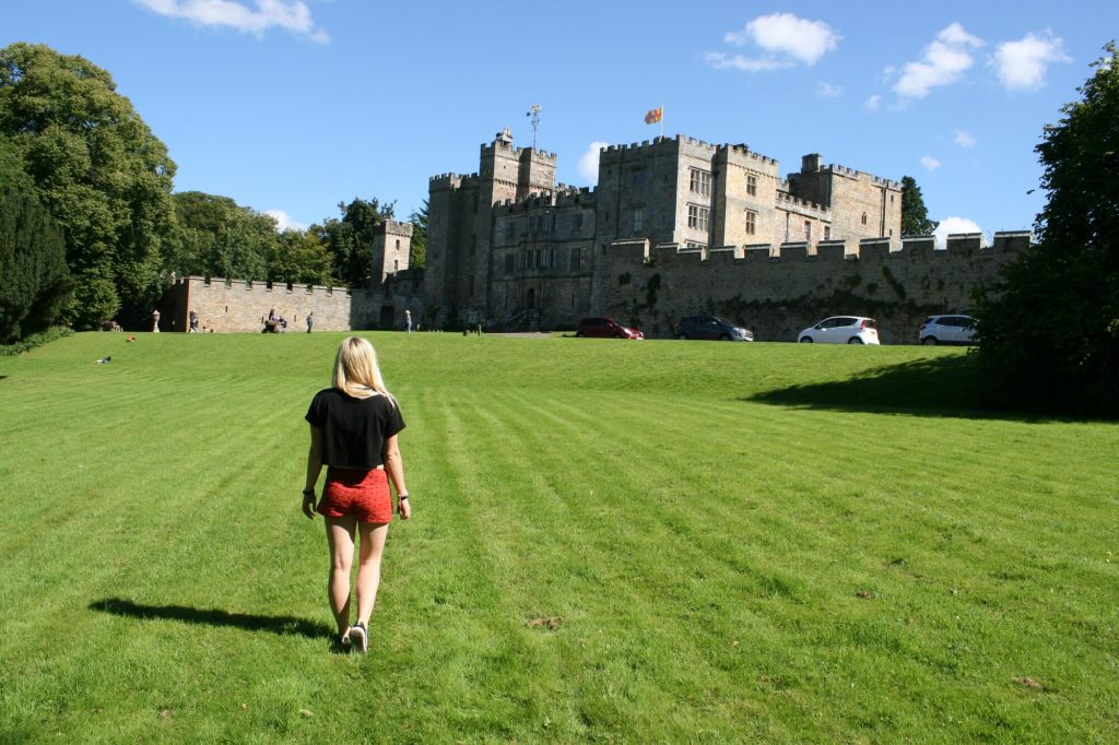 Woman in front of castle in Scotland in Summer