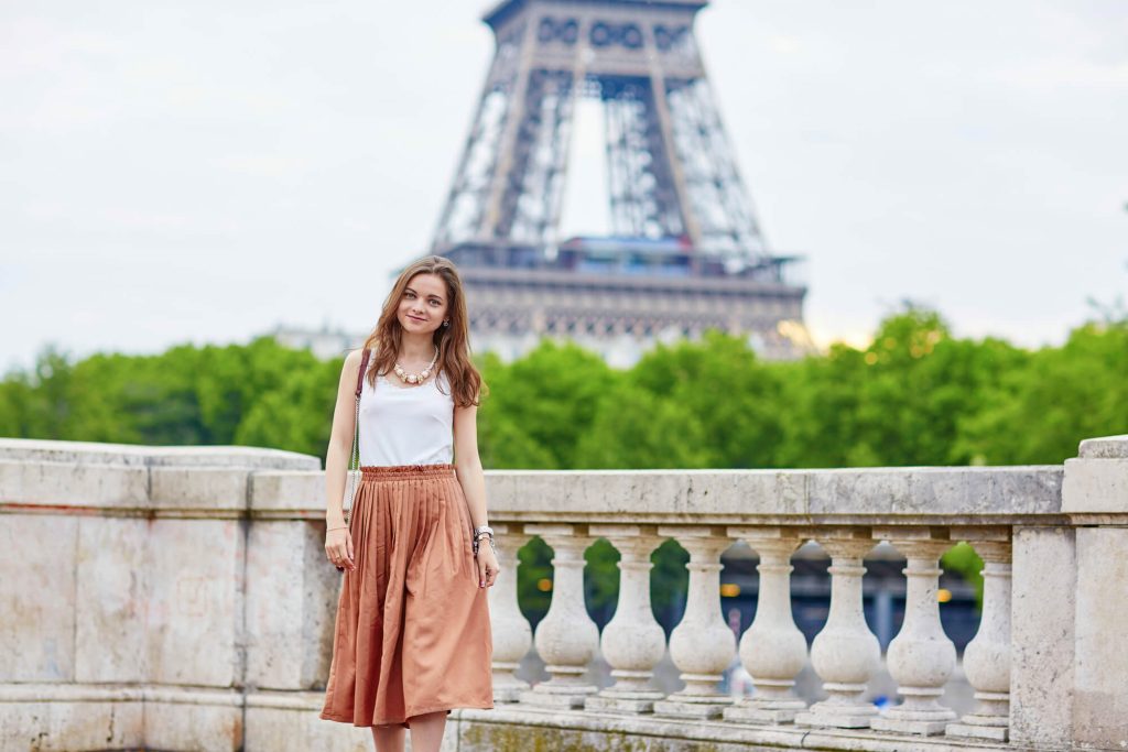 Woman in skirt and tank top in front of Eiffel Tower in background