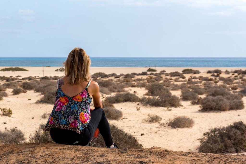 Woman overlooking beach and dunes in Corralejo natural park in Fuerteventura in October