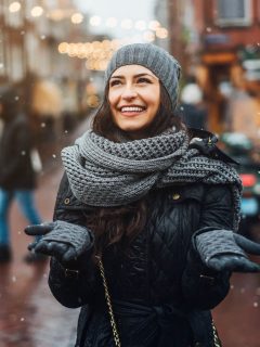 Woman in Amsterdam in December holding hands out to catch the snow