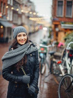 Woman in coat, hat and scarf on street in Amsterdam in November