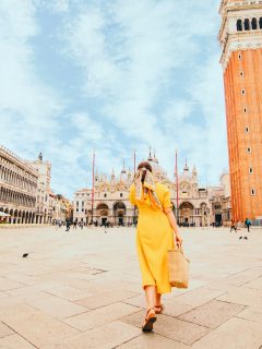 Woman in yellow dress in front of St Marks Basilica Venice