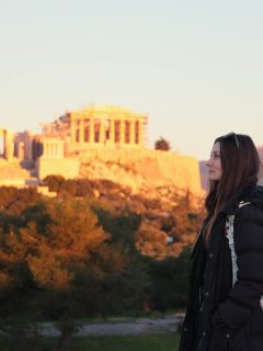 Woman stood with Parthenon in background with autumn trees