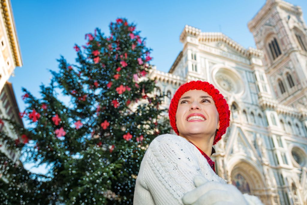 Woman in front of FLorence Duomo in December with Christmas tree
