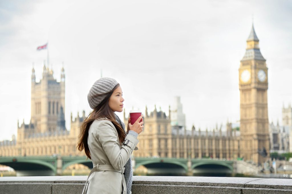 Woman standing in Winter clothes in front of Big Ben and Houses of Parliament in London in February