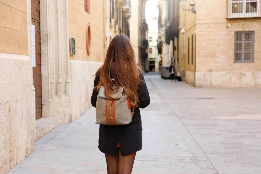 Woman in Spain with the back to her camera carrying a backpack