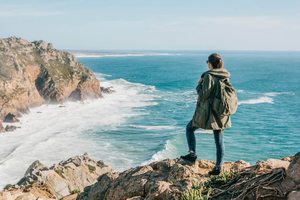 Woman standing overlooking ocean in Portugal in March
