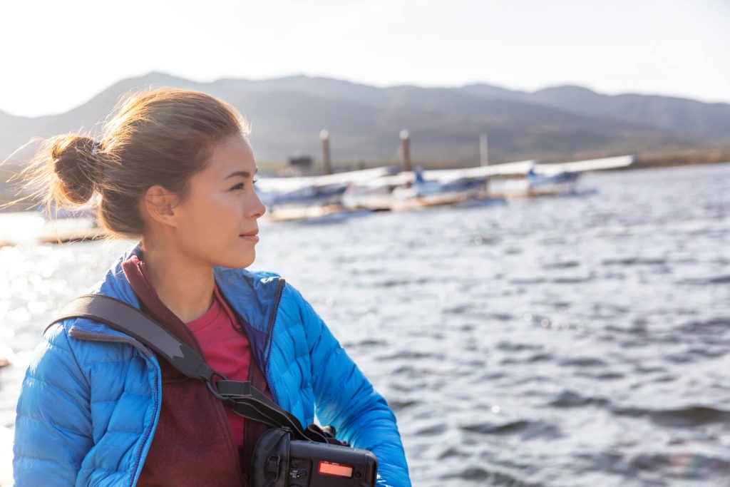 Woman in outdoor wear with seaplanes in background on an Alaskan cruise