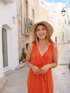 Woman in an orange dress and straw hat in Italy Europe in Summer