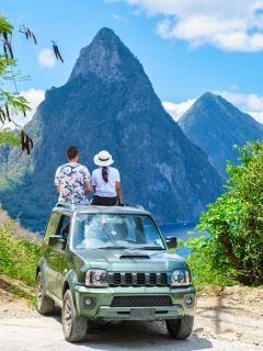 Couple sat on top of jeep in St Lucia looking at mountains