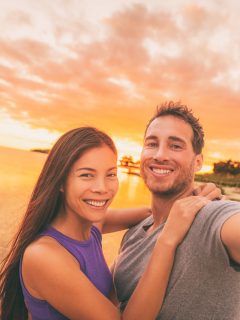 Couple at sunset taking selfie on beach in FLorida