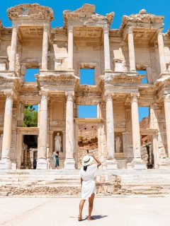 Woman in white dress looking at Ephesus ruins in Turkey